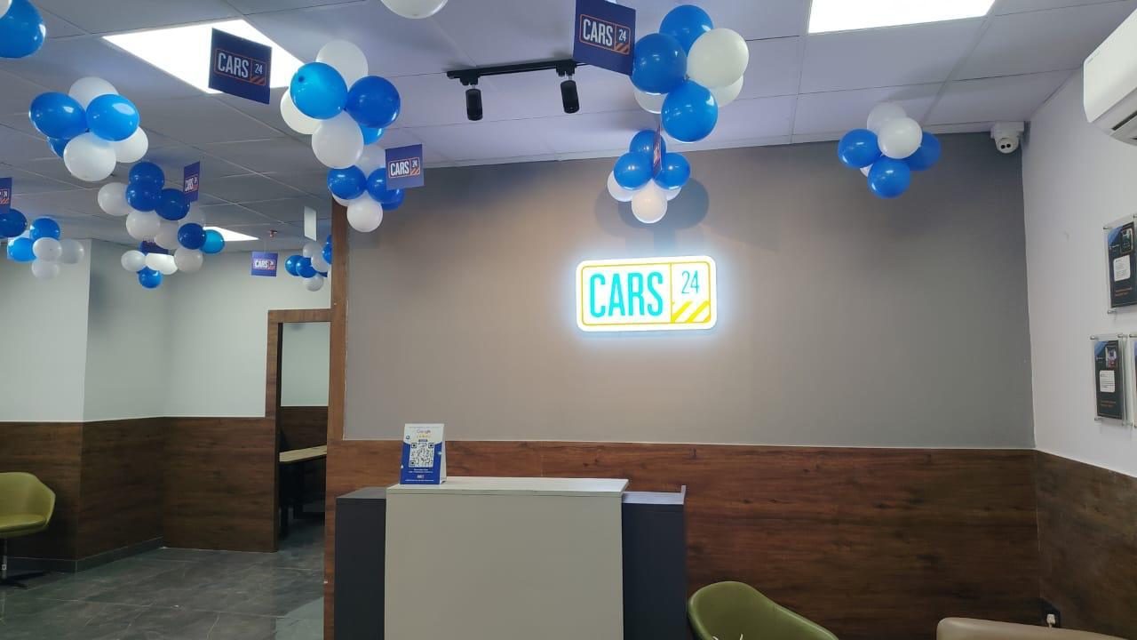 CARS24 reception with illuminated logo and wood-panel wall
