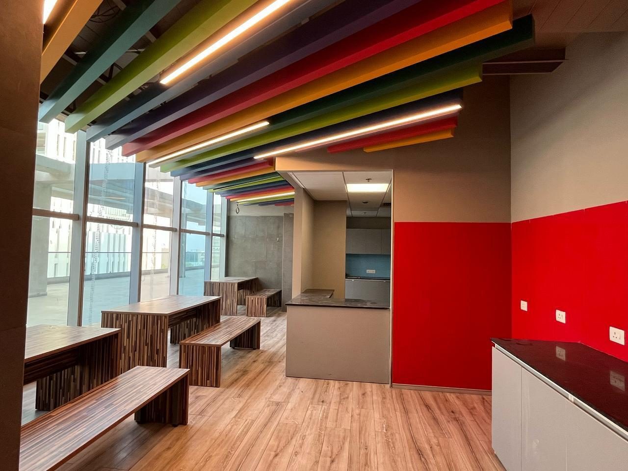 Open workspace with colourful ceiling baffles
